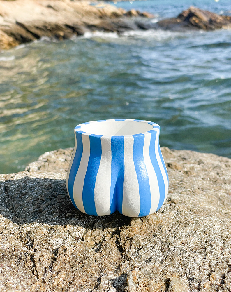 Fessier Cabanon bleu Cassis sur un rocher de dos, face à la mer