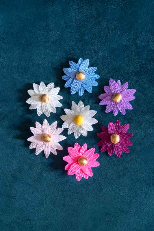 Broches Marguerite de Maison Tessier en 7 coloris différents, sur tissus velour émeraude