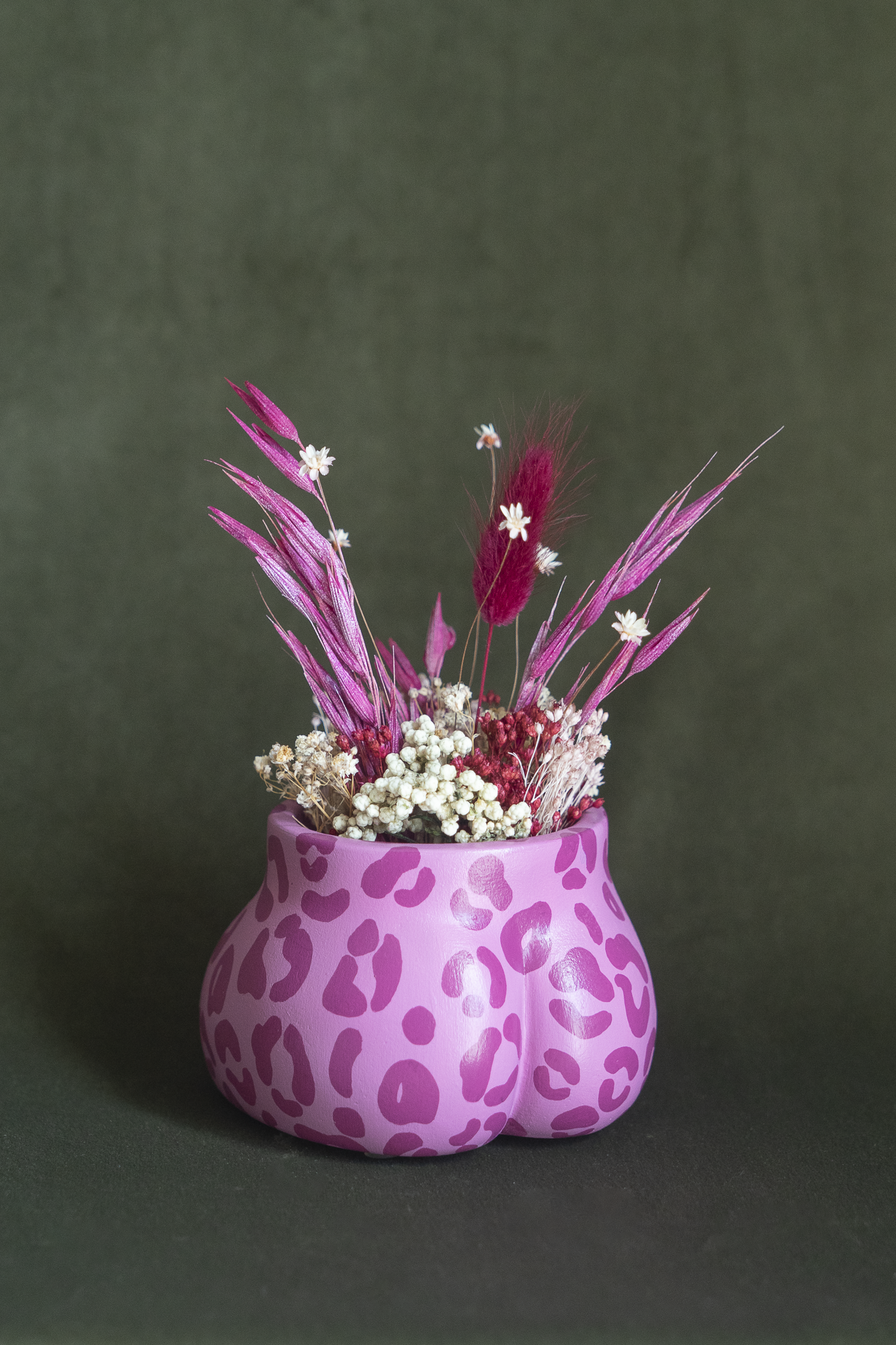 Mini cache-pot Fessier imprimé léopard rose et fuchsia en résine écologique, côté fesses, garni d'un bouquet de fleurs séchées avec lagures, avoine, gypsophiles, glixias, phalaris, hortensias colorées fuchsia et blanches sur fond kaki, objet déco floral original fait main par Maison Tessier