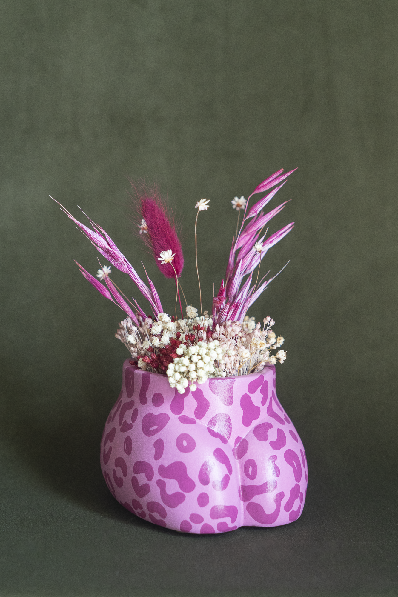 Mini cache-pot Fessier imprimé léopard rose et fuchsia en résine écologique, côté pubis, garni d'un bouquet de fleurs séchées avec lagures, avoine, gypsophiles, glixias, phalaris, hortensias colorées fuchsia et blanches sur fond kaki, objet déco floral original fait main par Maison Tessier