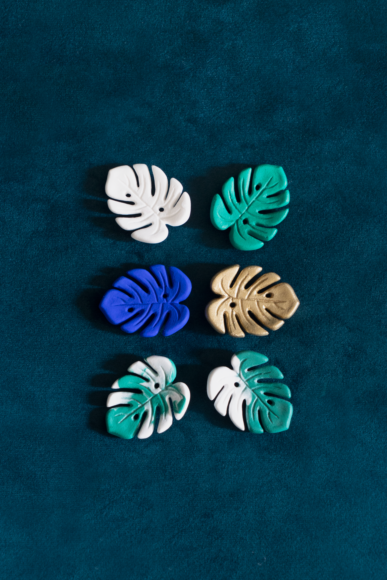 Six Mini Monstera broches de Maison Tessier en émeraude, variegata panachée, variegata bicolore, dorée, Blanc, Bleu Klein sur fond vert émeraude