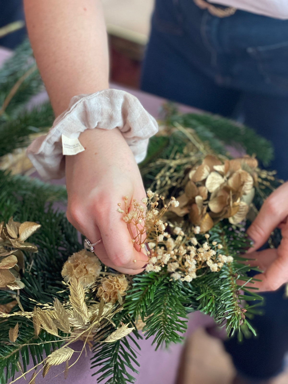 Couronne de noel dorée en train d'être fabriquer à la main