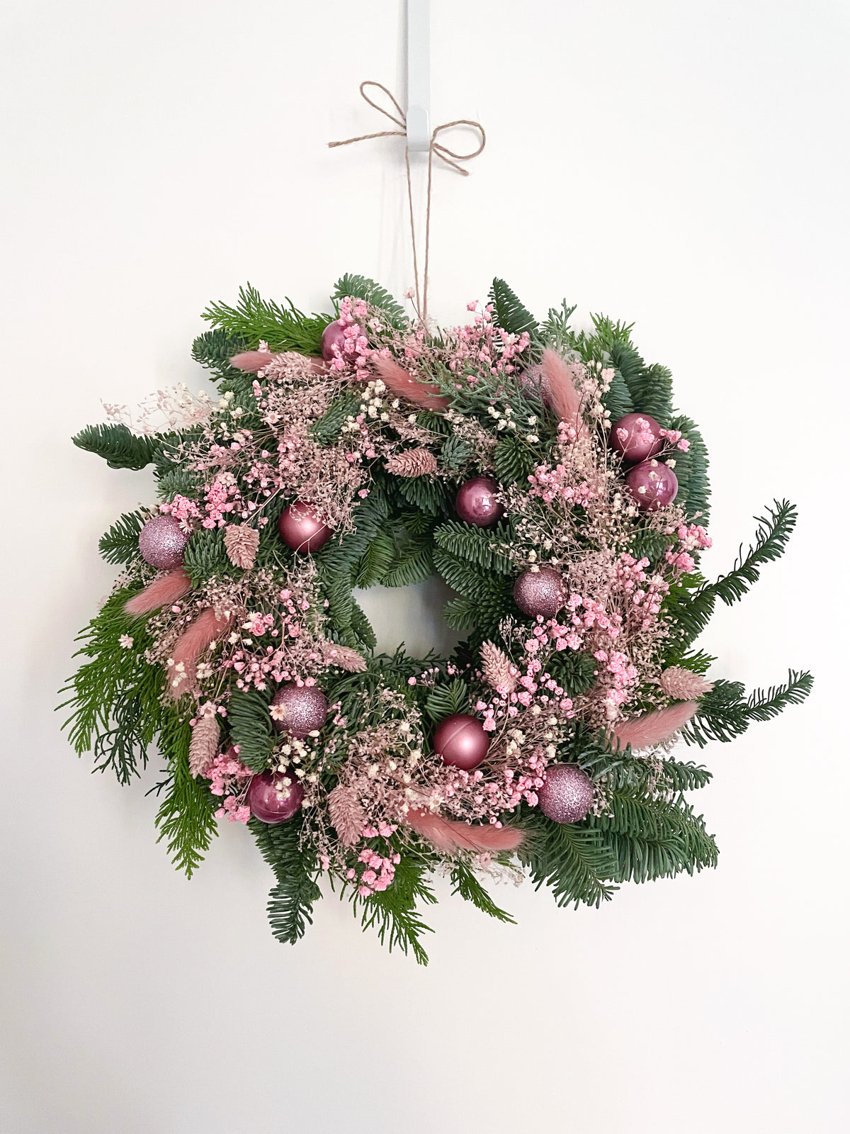 Couronne de noel rose et crème sur fond blanc