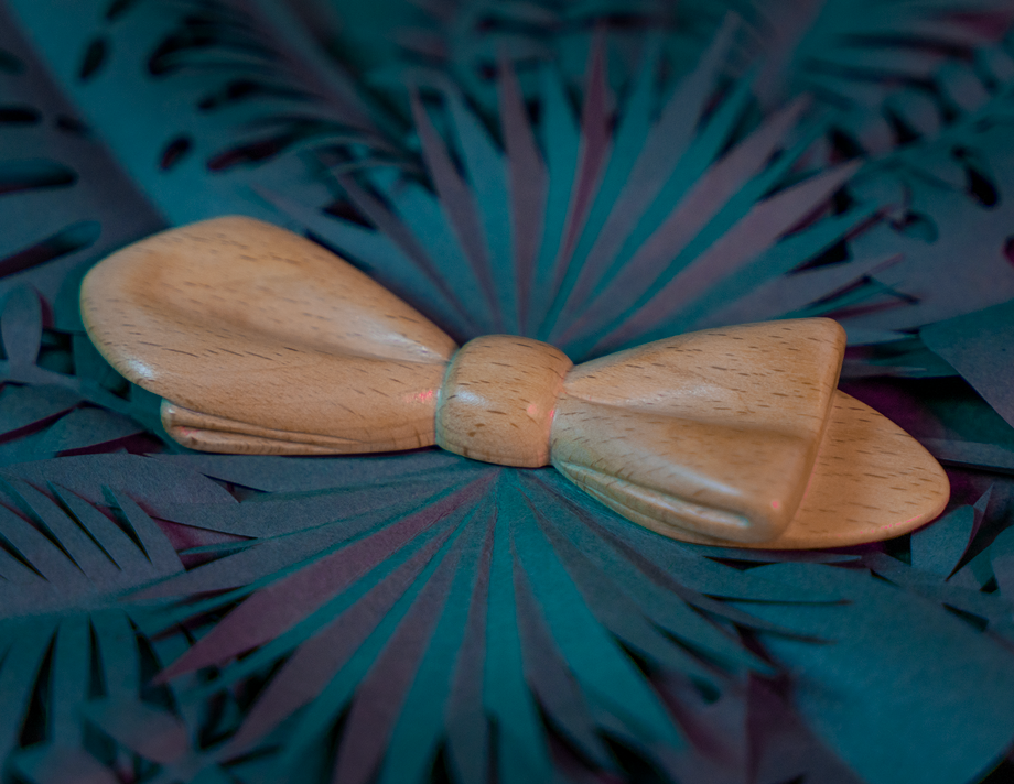 Noeud papillon en bois Maison Tessier en Hêtre sur fond de feuilles tropicales en papier, vue de 3/4